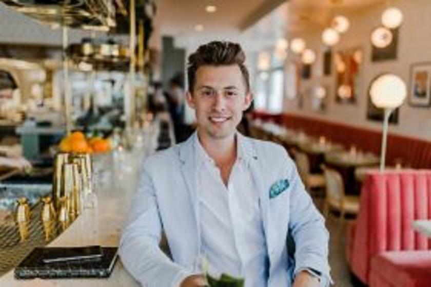 Young man in white suite smiling