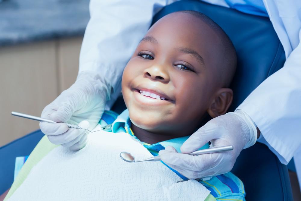 Young boy smiling in dental office as dentist is about to start working