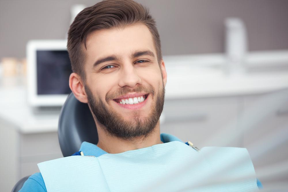 Young man in dental office smiling